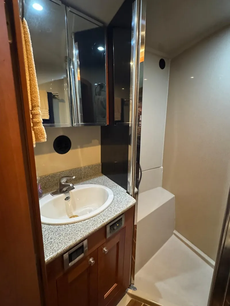 Slide: The Image of 2003 Rampage 45 Convertible yacht bathroom with sink, shower, and wooden cabinetry. - 26