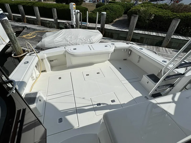 Slide: The Image of 2003 Rampage 45 Convertible boat deck with seating and storage, docked at a marina. - 30