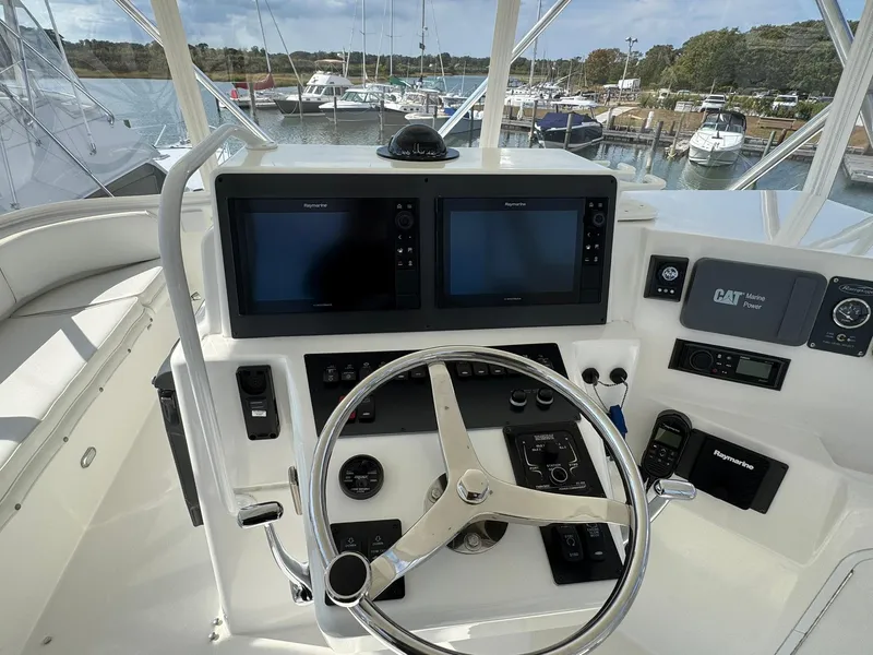 Slide: The Image of Control panel of a 2003 Rampage 45 Convertible boat with dual screens and steering wheel. - 37