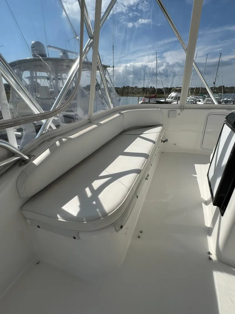 Slide: The Image of 2003 Rampage 45 Convertible boat interior with white seating and marina view. - 40