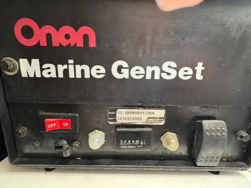 Slide: The Image of Onan Marine GenSet control panel with switches and hour meter, Rampage 45 Convertible 2003. - 48