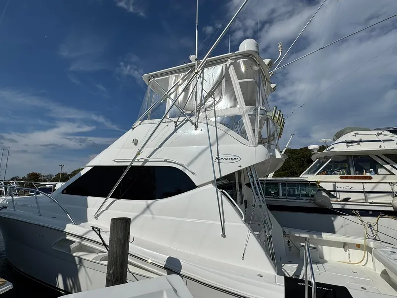 Slide: The Image of 2003 Rampage 45 Convertible yacht docked under a clear blue sky. - 5