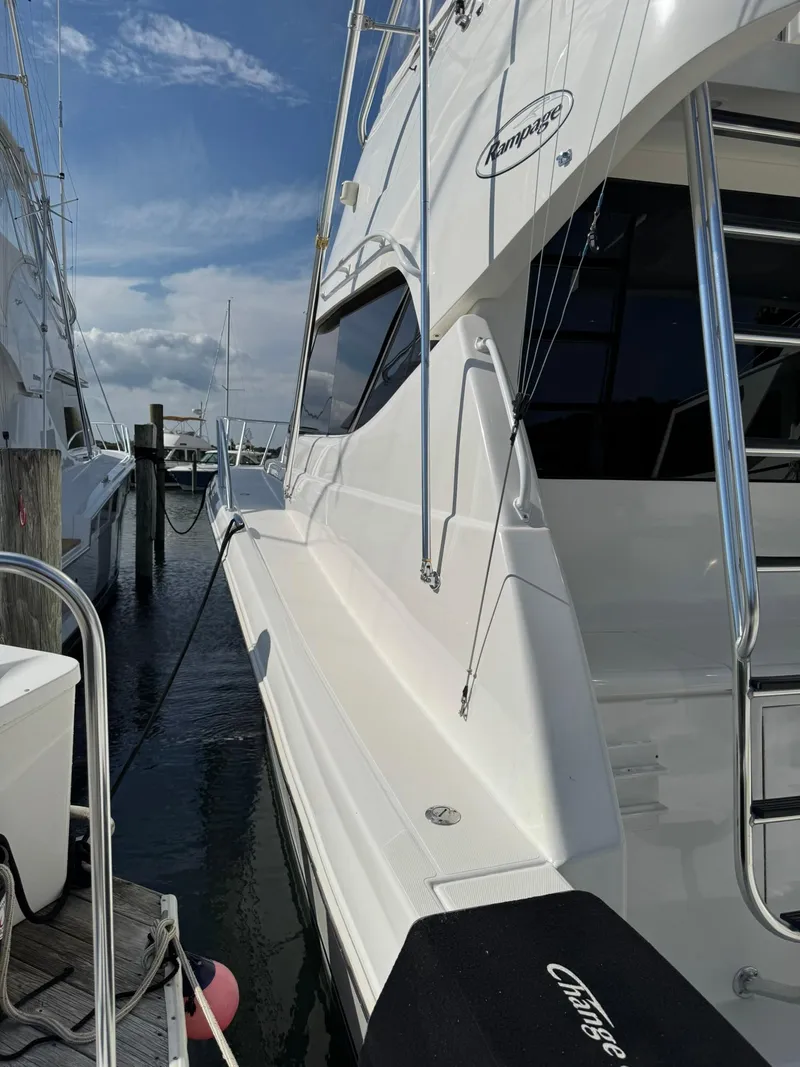 Slide: The Image of 2003 Rampage 45 Convertible yacht docked at marina under blue sky. - 6