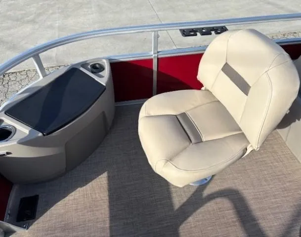 Slide: The Image of 2023 Sun Tracker Bass Buggy 18 DLX boat interior with beige seating and red paneling. - 11