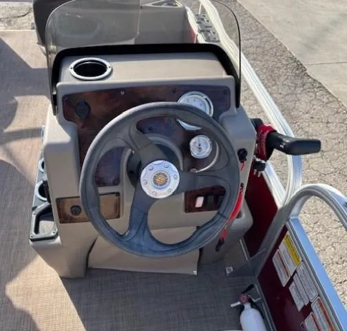 Slide: The Image of 2023 Sun Tracker Bass Buggy 18 DLX steering console with gauges and controls. - 13