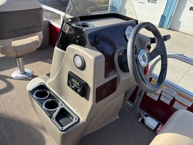Slide: The Image of 2023 Sun Tracker Bass Buggy 18 DLX boat console with steering wheel and cup holders. - 14