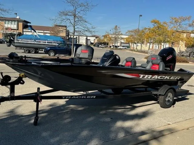 Slide: The Image of 2025 Tracker Pro Team 190 boat in parking lot, black with red accents. - 2