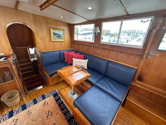 Slide: The Image of Interior of 1986 C. Raymond Hunt Design Yacht with blue seating and wooden accents. - 11