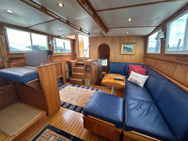 Slide: The Image of Luxurious 1986 C. Raymond Hunt Design yacht interior with blue seating and wooden accents. - 12