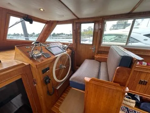 Slide: The Image of 1986 C. Raymond Hunt Design Yacht interior with wooden helm and seating. - 16