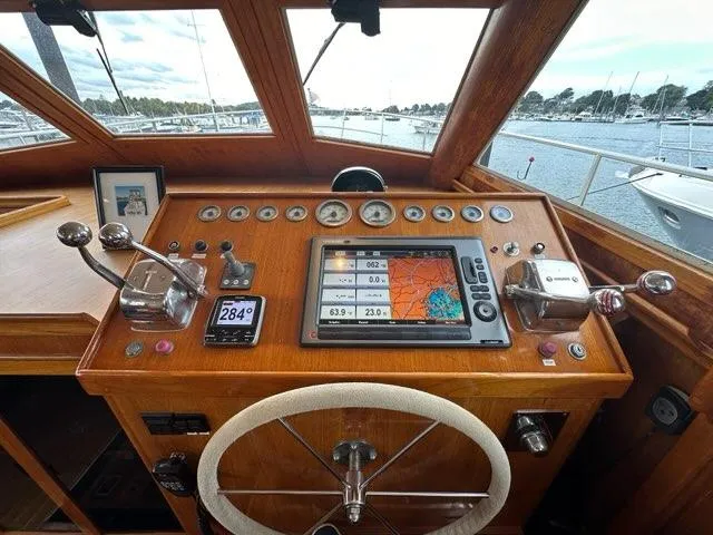 Slide: The Image of 1986 Custom C. Raymond Hunt Design Yacht cockpit with navigation instruments and wooden steering wheel. - 18