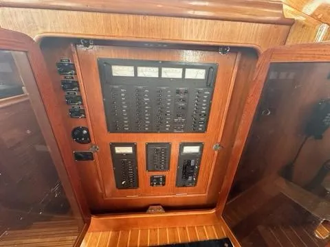 Slide: The Image of Electrical panel on 1986 C. Raymond Hunt Design Yacht, featuring wooden cabinetry and control switches. - 19