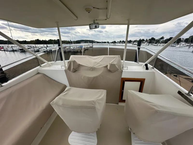 Slide: The Image of 1986 Custom C. Raymond Hunt Design Yacht interior with covered seating, overlooking marina. - 2