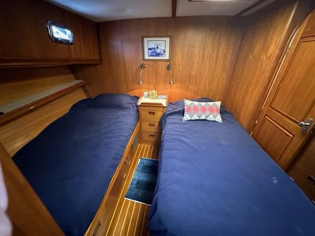 Slide: The Image of Cozy 1986 C. Raymond Hunt Design yacht cabin with twin beds and wooden interior. - 23