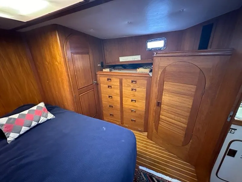 Slide: The Image of Cozy 1986 C. Raymond Hunt Design yacht cabin with wooden interior and bed. - 25