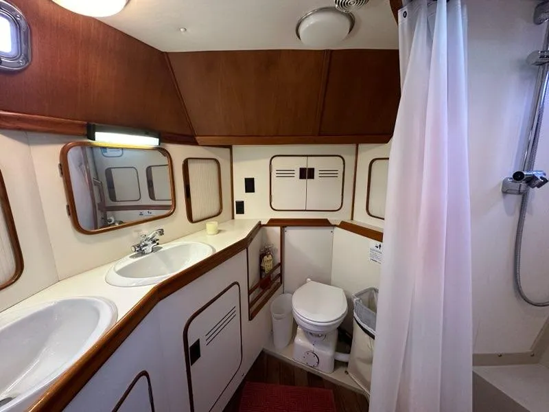 Slide: The Image of Luxurious 1986 yacht bathroom with dual sinks, shower, and wooden accents. - 27