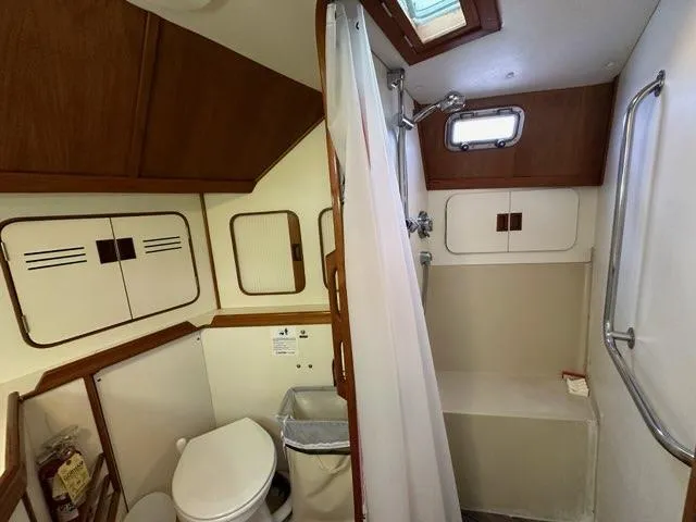 Slide: The Image of 1986 C. Raymond Hunt Design Yacht bathroom with shower, toilet, and wooden cabinets. - 28