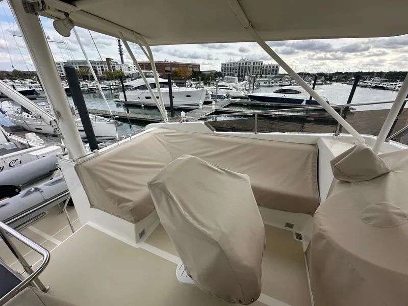 Slide: The Image of 1986 Custom C. Raymond Hunt Design Yacht at marina, featuring covered seating and helm. - 3