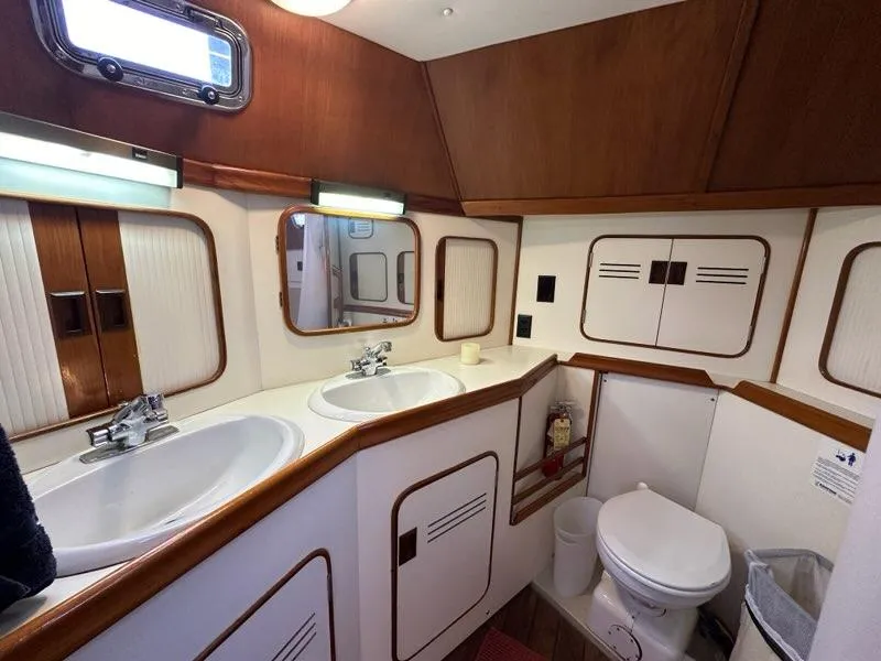 Slide: The Image of Luxurious 1986 C. Raymond Hunt Design yacht bathroom with dual sinks and wooden accents. - 30