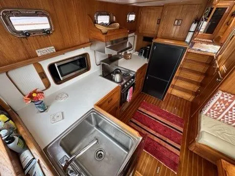 Slide: The Image of 1986 Custom C. Raymond Hunt Design Yacht kitchen with wood interior, sink, stove, and fridge. - 37