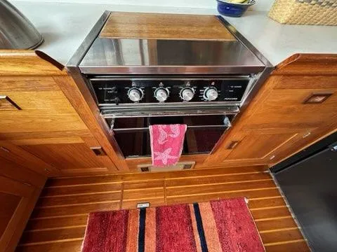 Slide: The Image of 1986 Custom C. Raymond Hunt Design Yacht kitchen with stove and wooden cabinetry. - 39