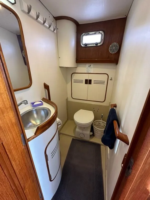 Slide: The Image of 1986 Custom C. Raymond Hunt Design Yacht bathroom with sink, toilet, and wooden accents. - 43
