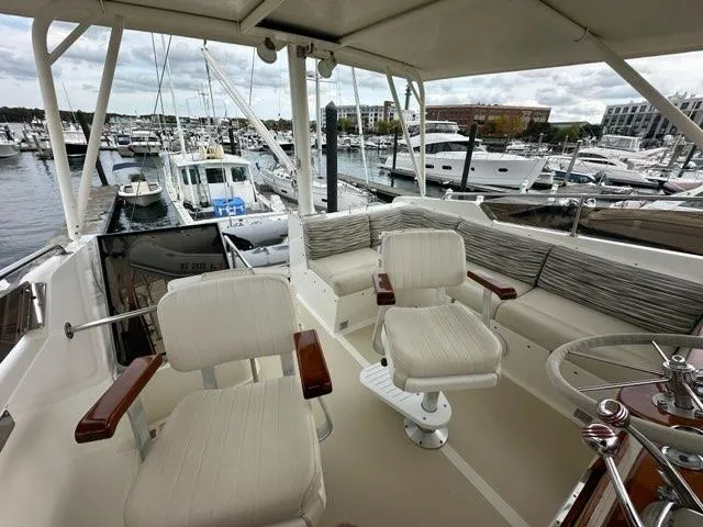 Slide: The Image of 1986 Custom C. Raymond Hunt Design Yacht interior with marina view, featuring plush seating and helm. - 5