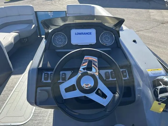 Slide: The Image of 2025 Godfrey Monaco 235SB boat dashboard with Lowrance display and steering wheel. - 9