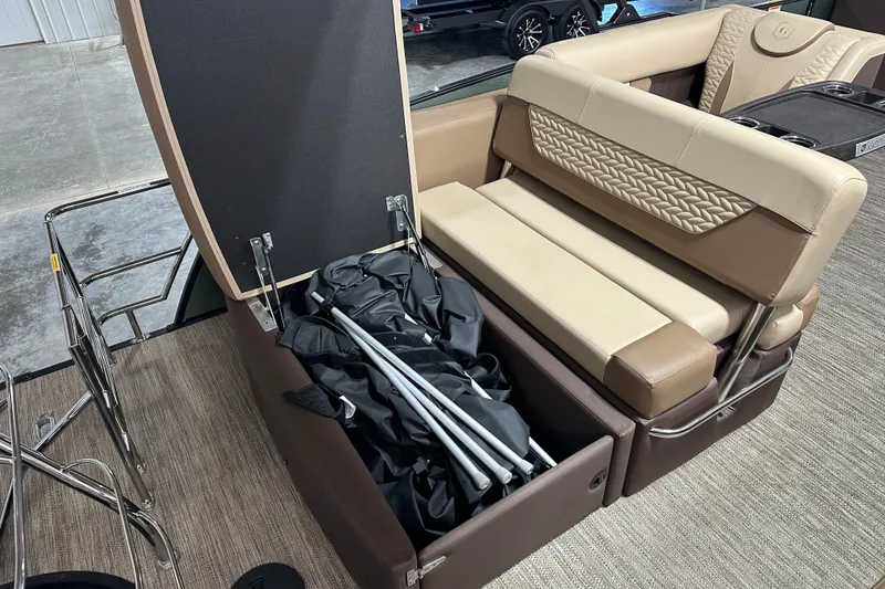 Slide: The Image of 2025 Godfrey MONACO 235 SFL boat with open storage compartment and beige seating. - 12