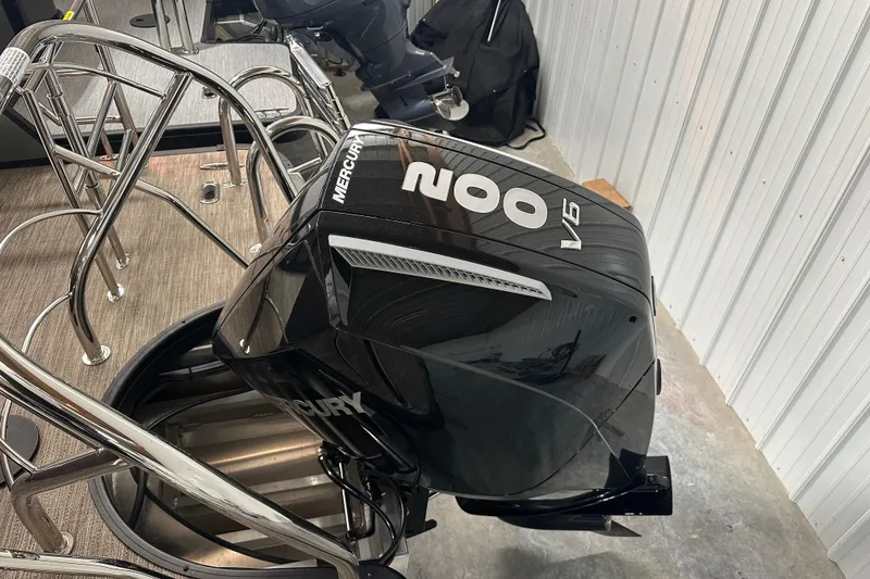 Slide: The Image of 2025 Godfrey MONACO 235 SFL boat with Mercury 200 V6 outboard engine in a garage. - 13