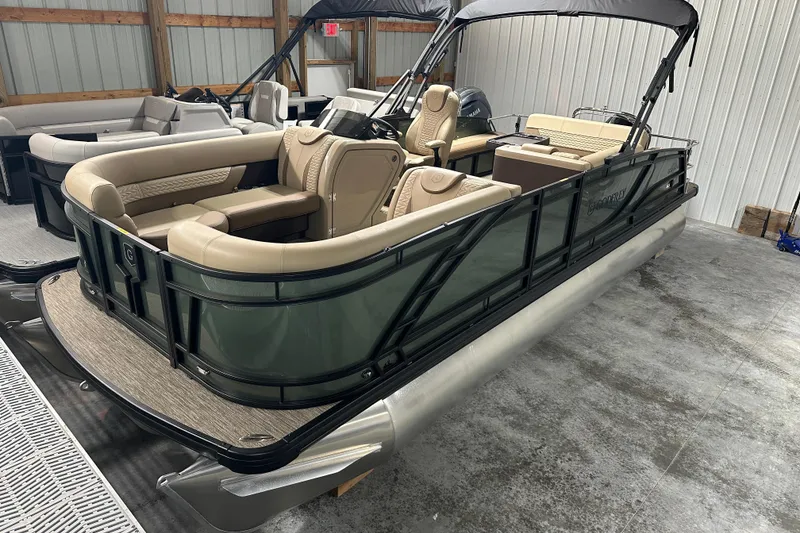 Slide: The Image of 2025 Godfrey Monaco 235 SFL pontoon boat with luxurious seating and sleek design in a showroom. - 2