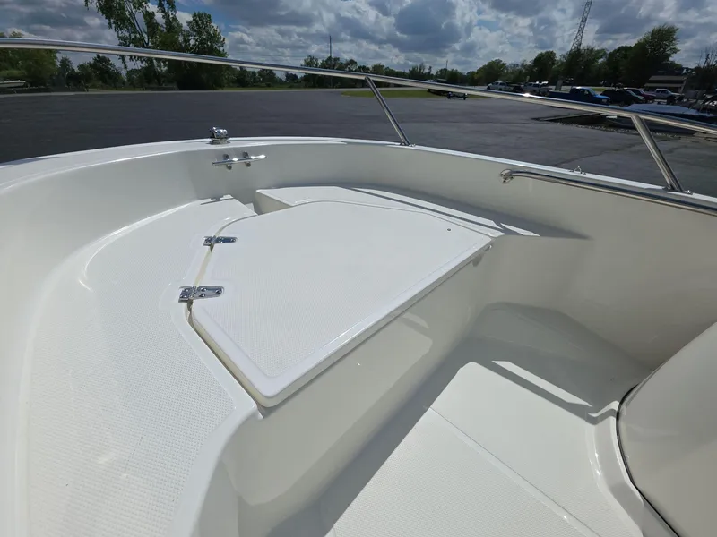 Slide: The Image of 2025 Boston Whaler 130 Super Sport boat interior with white seating and storage. - 2