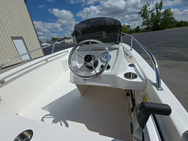 Slide: The Image of 2025 Boston Whaler 130 Super Sport boat interior with steering wheel and controls. - 9