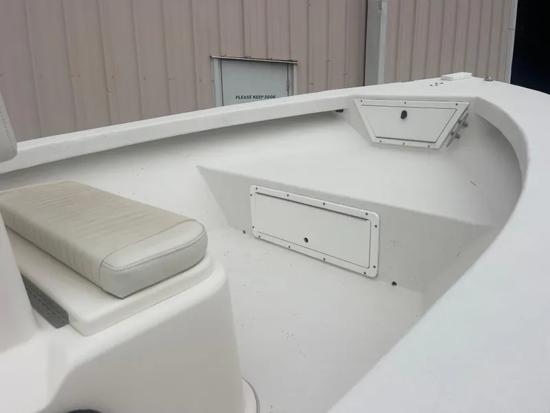 Slide: The Image of 2021 May-Craft 19 Cape Classic boat interior with white seating and storage compartments. - 11