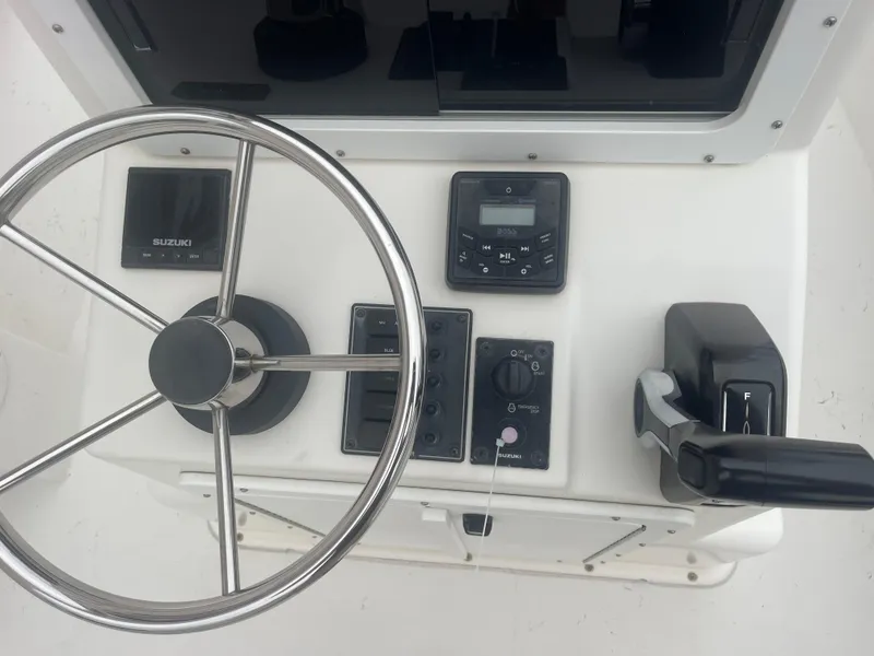 Slide: The Image of 2021 May-Craft 19 Cape Classic boat dashboard with steering wheel and control panel. - 14