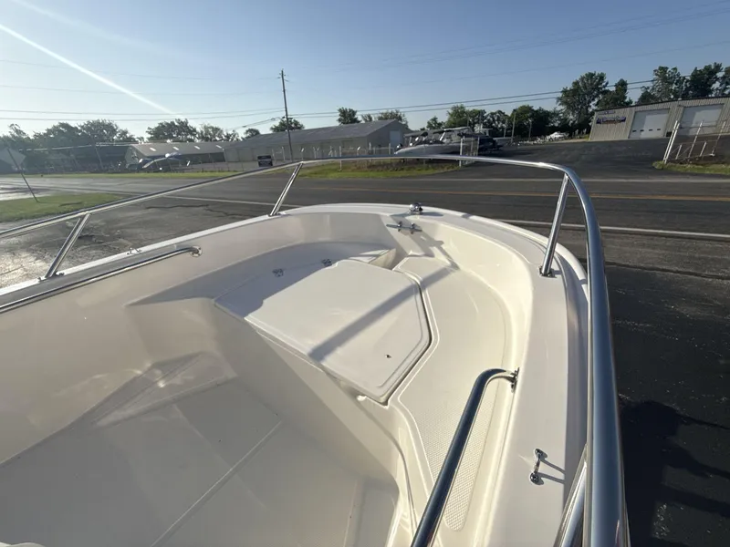 Slide: The Image of 2025 Boston Whaler 130 Super Sport boat, showcasing sleek bow design and stainless steel railings. - 12