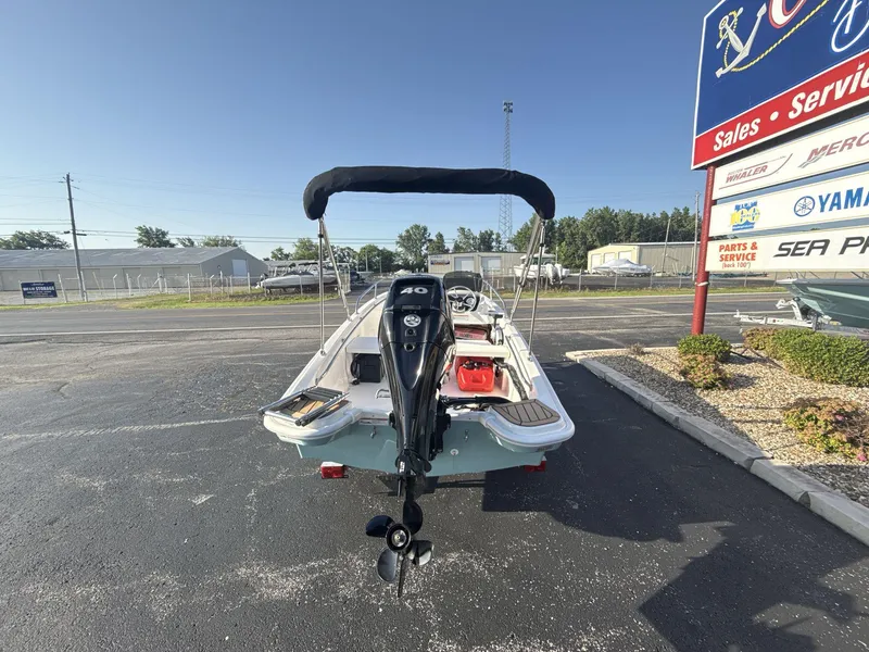Slide: The Image of 2025 Boston Whaler 130 Super Sport boat with outboard motor in dealership lot. - 3