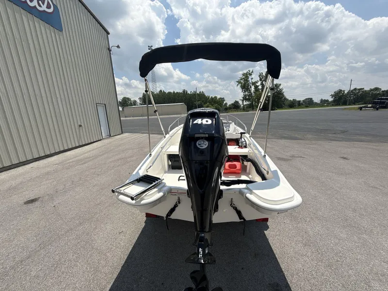 Slide: The Image of 2025 Boston Whaler 130 Super Sport boat with 40 HP engine, parked outdoors. - 5
