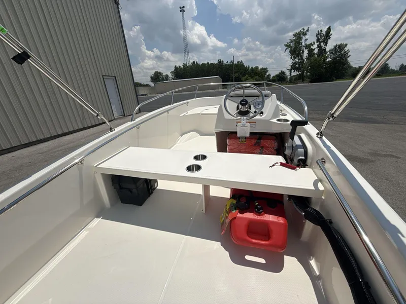 Slide: The Image of 2025 Boston Whaler 130 Super Sport boat interior with steering wheel and seating. - 6