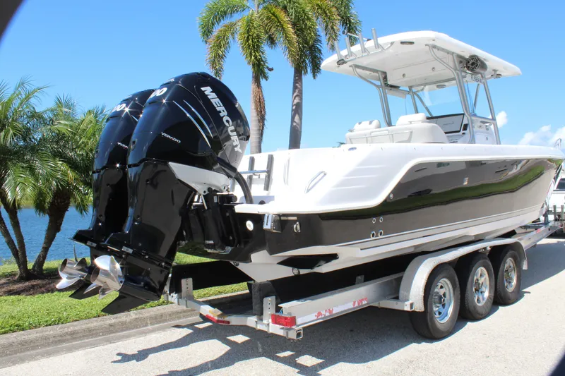 Slide: The Image of 2009 Donzi 35 ZFX Cuddy boat on trailer, twin Mercury engines, palm trees in background. - 13
