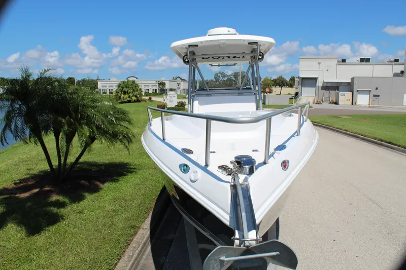 Slide: The Image of 2009 Donzi 35 ZFX Cuddy boat on trailer, parked near palm trees and industrial buildings. - 20