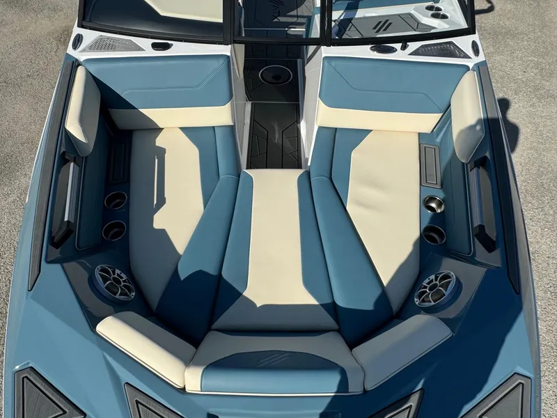 Slide: The Image of 2025 ATX Surf Boats 22 Type-S interior with blue and beige seating, cup holders, and speakers. - 5