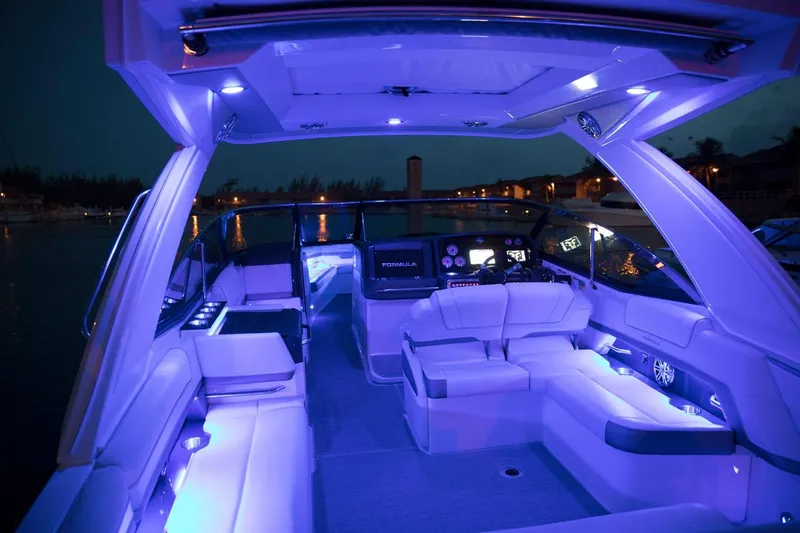 Slide: The Image of 2025 Formula 330 CBR boat interior with blue LED lighting at night. - 18