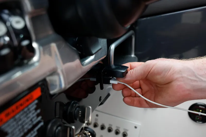 Slide: The Image of Hand plugging cable into 2025 Formula 330 CBR dashboard. - 25