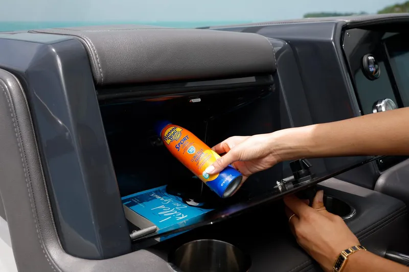 Slide: The Image of Hand placing sunscreen in Formula 330 CBR 2025 boat's glove compartment. - 26