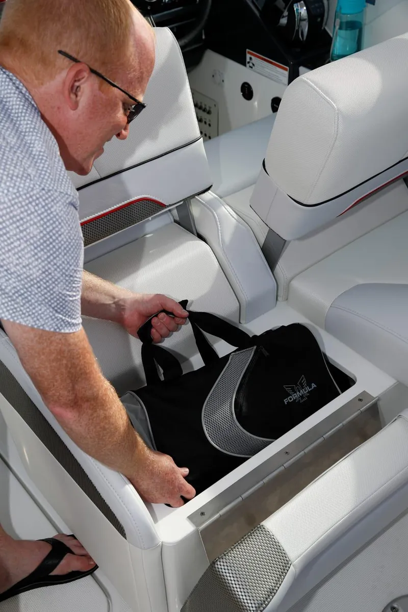 Slide: The Image of Man placing bag in storage compartment of 2025 Formula 330 CBR boat. - 37