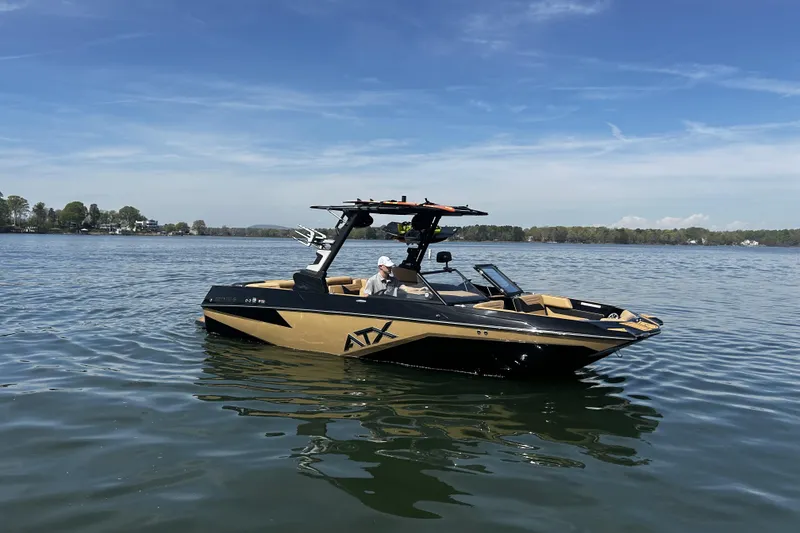 The Image of 2025 ATX Surf Boats 22 Type-S on a serene lake under a clear blue sky. - 0