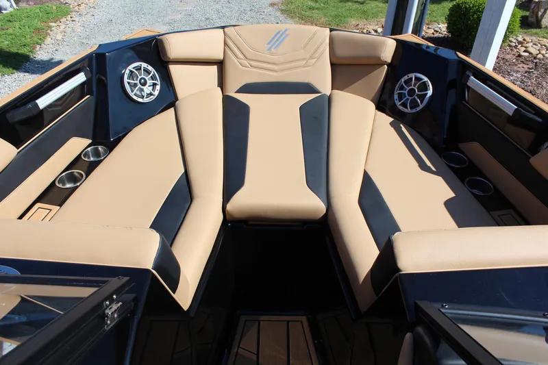 Slide: The Image of 2025 ATX Surf Boats 22 Type-S interior with tan and black seating, cup holders, and speakers. - 18
