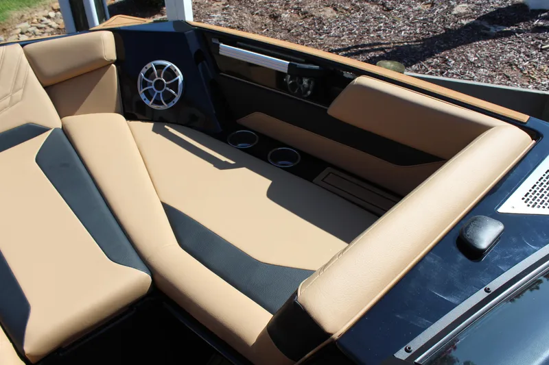 Slide: The Image of 2025 ATX Surf Boats 22 Type-S interior with tan and black seating, cup holders, and speaker. - 25