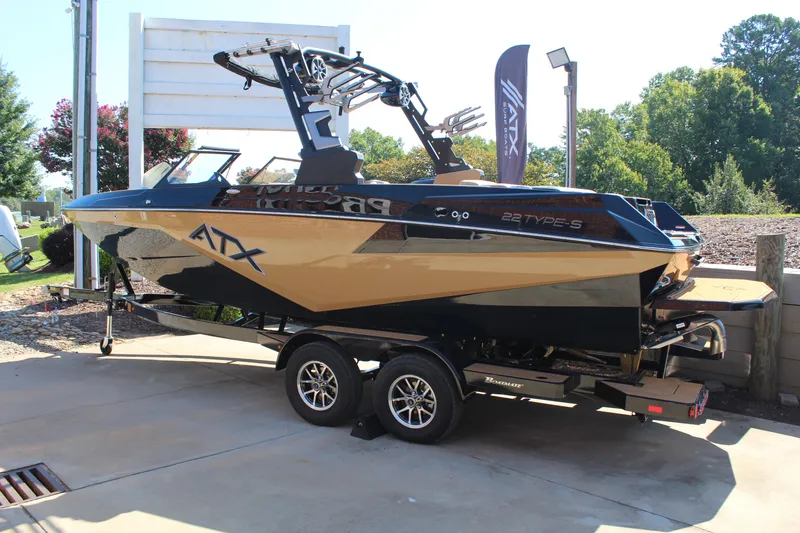 Slide: The Image of 2025 ATX Surf Boats 22 Type-S on trailer, sleek design, parked outdoors. - 3